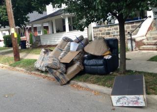 Picture of mattress and stuffed furniture at the curb